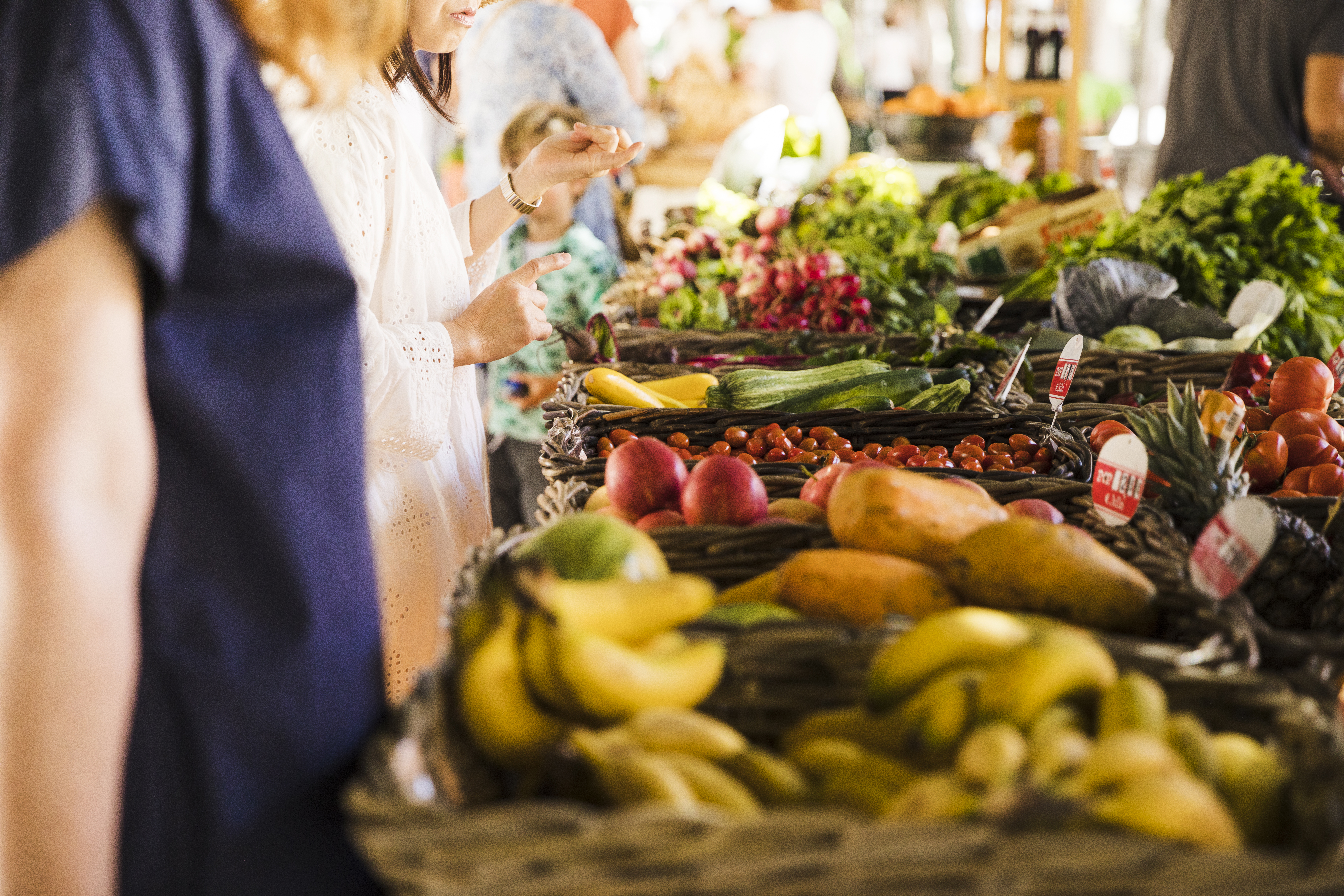 People selecting fruits and vegetables at a local market, promoting responsible consumption and sustainable products